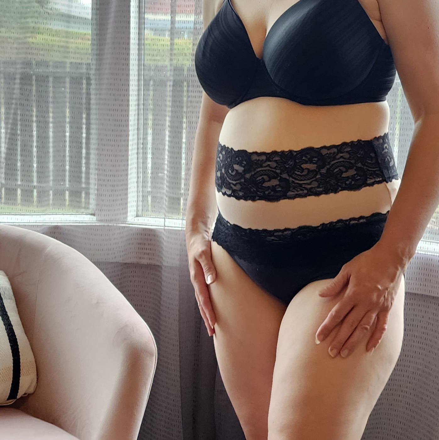 Pregnant woman wearing beige black lacey belly band