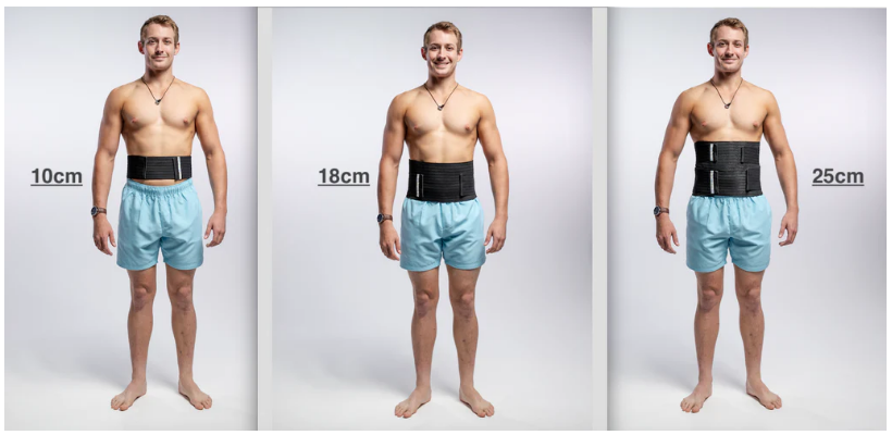 Male standing in light blue shorts wearing differnt sizes of hernia belt