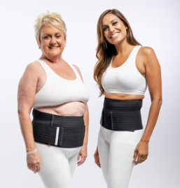 Two women smiling against white backdrop, wearing black Hernia Belts.