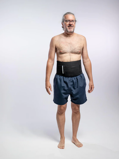 Man standing in blue shorts wearing a black hernia belt kidney belt