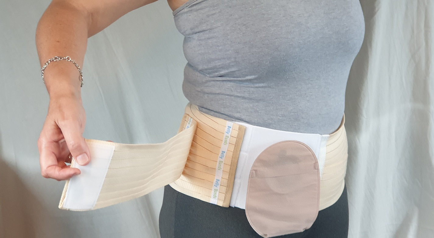 Person wearing a bisque belly band ostomy belt with hole for stoma